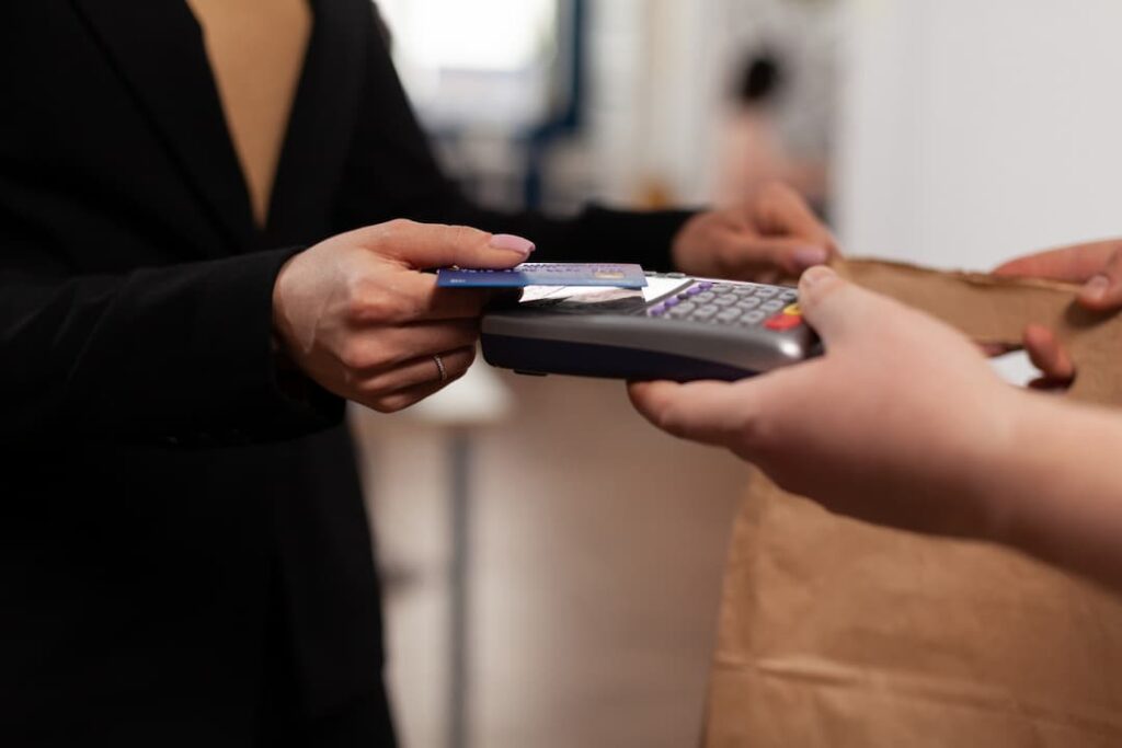 mujer pagando en punto de venta con tarjeta de crédito