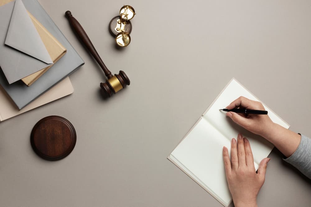 ¿Cuánto tarda en salir un juicio por abusos sexuales en España? 2 Mujer en escritorio escribiendo en libreta