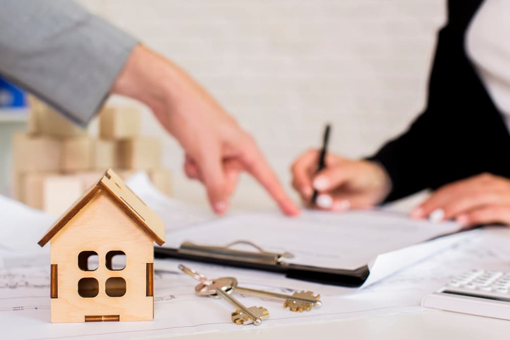 Mujer firmando contrato de compraventa de casa